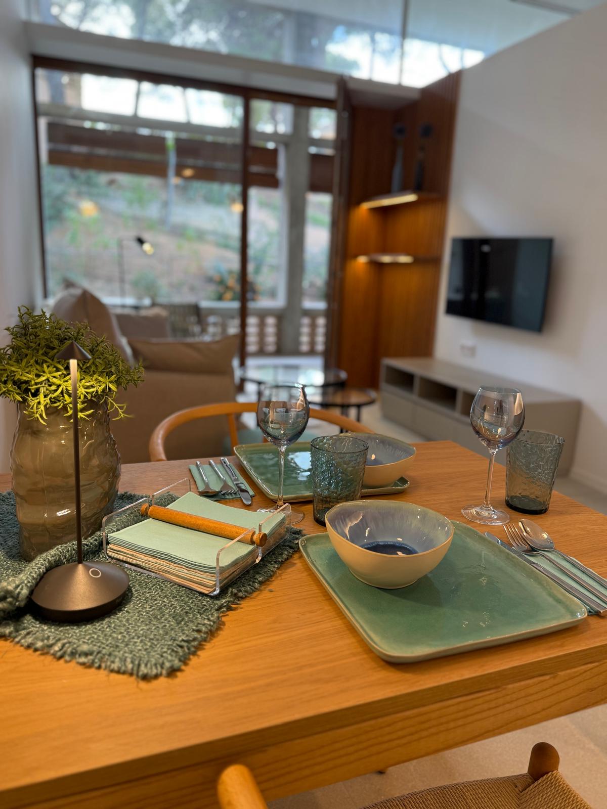 Suite dining table set with ceramic tableware and garden views